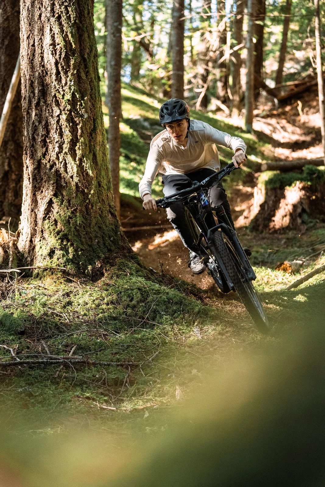 Mountainbiker nimmt eine Kurve an einem Baum im Wald